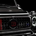 Zbliżenie na grill czarnego Mercedes-Benz Klasa G Brabus z czerwonymi akcentami i logotypem Brabus