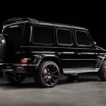 Boczny widok czarnego Mercedes-Benz Klasa G Brabus na ciemnym tle