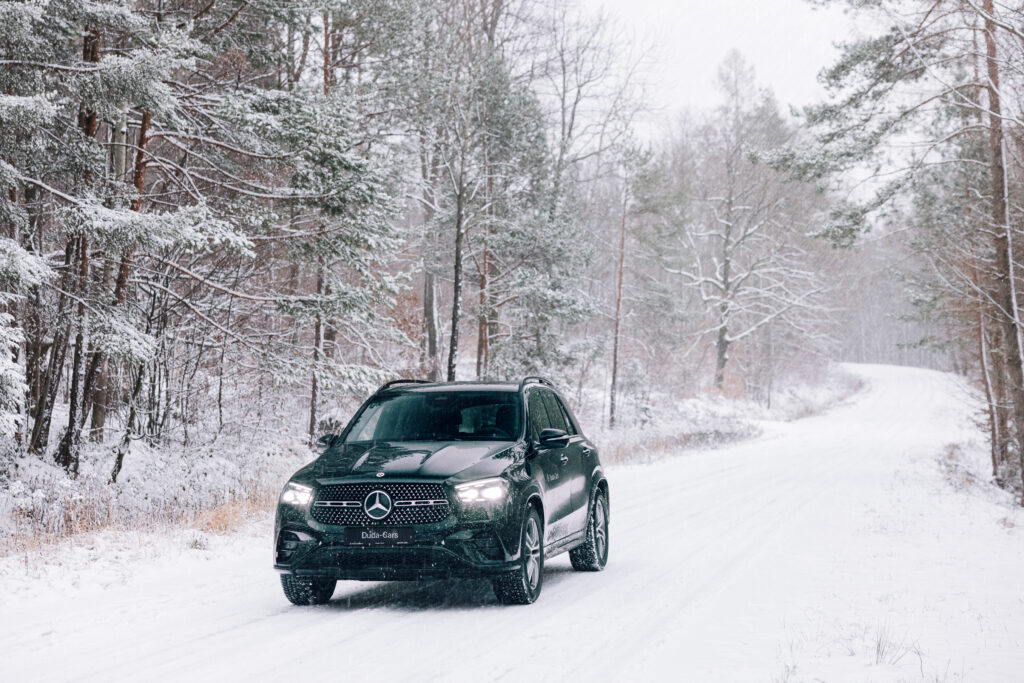 Czarny mercedes na zimowym tle w lesie